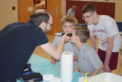 Pierre St-Laurent explaining the use of a refractometer to kids during STREAM Day (science outreach, May 2017)